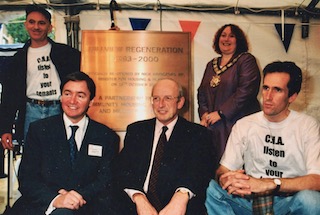 CHA chief Mick Sweeney (left, seated) with housing minister Nick Raynsford and mayor Heather Johnson at regneration unveiling in 2000. T-shirted tenants indicate that relations with CHA have got off to a bad start. Courtesy, J Mason copy